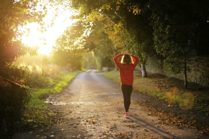 health - woman walking on pathway during daytime