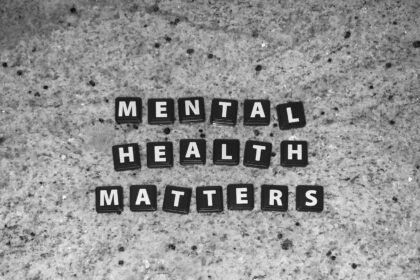 Black letter tiles spelling Mental Health Matters on a speckled grey stone surface